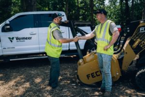 Fecon Mulching Equipment and Vermeer All Roads Pickup Truck with Sales Rep shaking hands